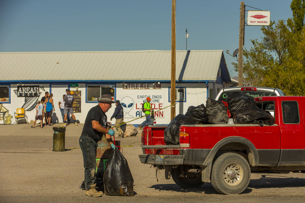 Kevin Dingo recoge bolsas de basura apiladas en el área de estacionamiento frente a Little A'L ...