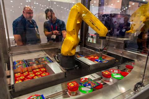 Un robot con Bosch Packaging Technology Inc. empaqueta almuerzos escolares para niños a travé ...