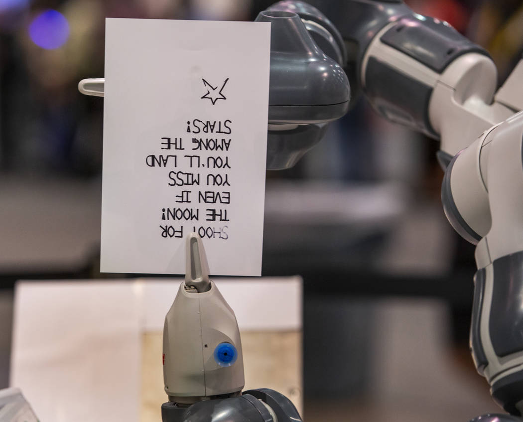 Un robot de Fanuc escribe y dobla una nota para agregarla a los almuerzos escolares para niños ...