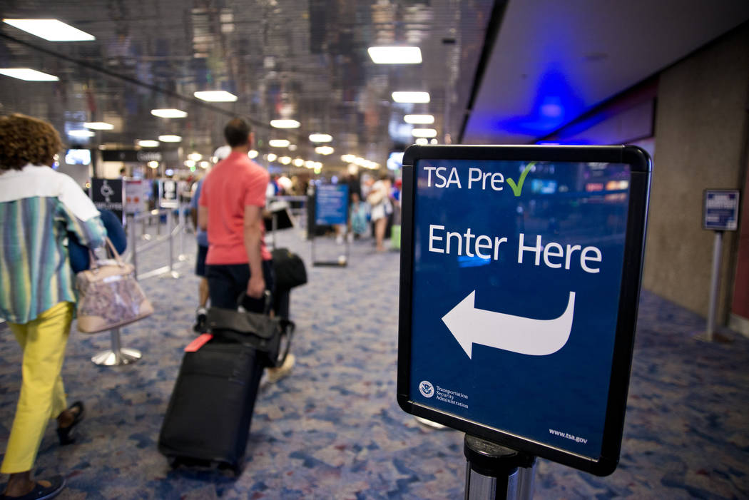 Pasajeros caminan hacia la línea de seguridad TSA PreCheck en el Aeropuerto Internacional McCa ...