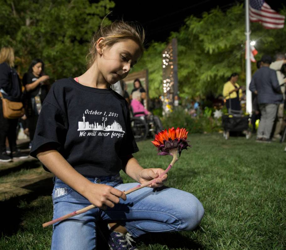 Ella Goldy sostiene un girasol rojo en honor a su madre Samantha Olander, quien sobrevivió al ...