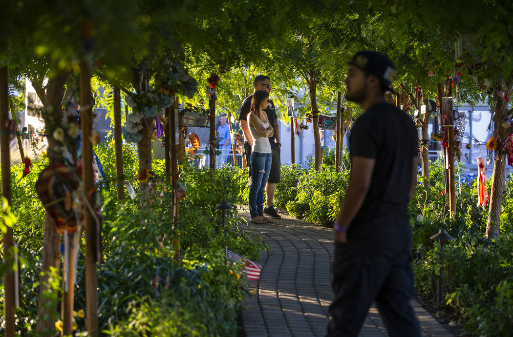 Los visitantes caminan por el sendero de árboles decorados en el Jardín de Curación de Las V ...