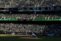 Los fans en el RingCentral Coliseum observan al lanzador de los Athletics de Oakland, Sean Mana ...