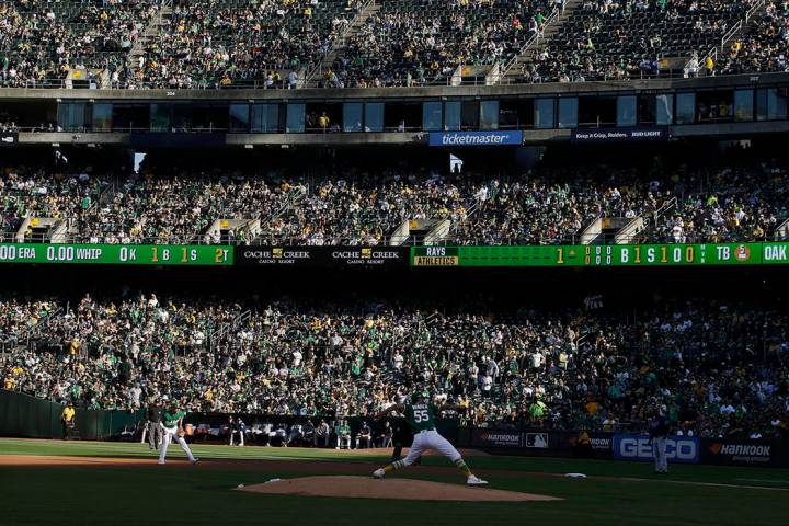 Los fans en el RingCentral Coliseum observan al lanzador de los Athletics de Oakland, Sean Mana ...