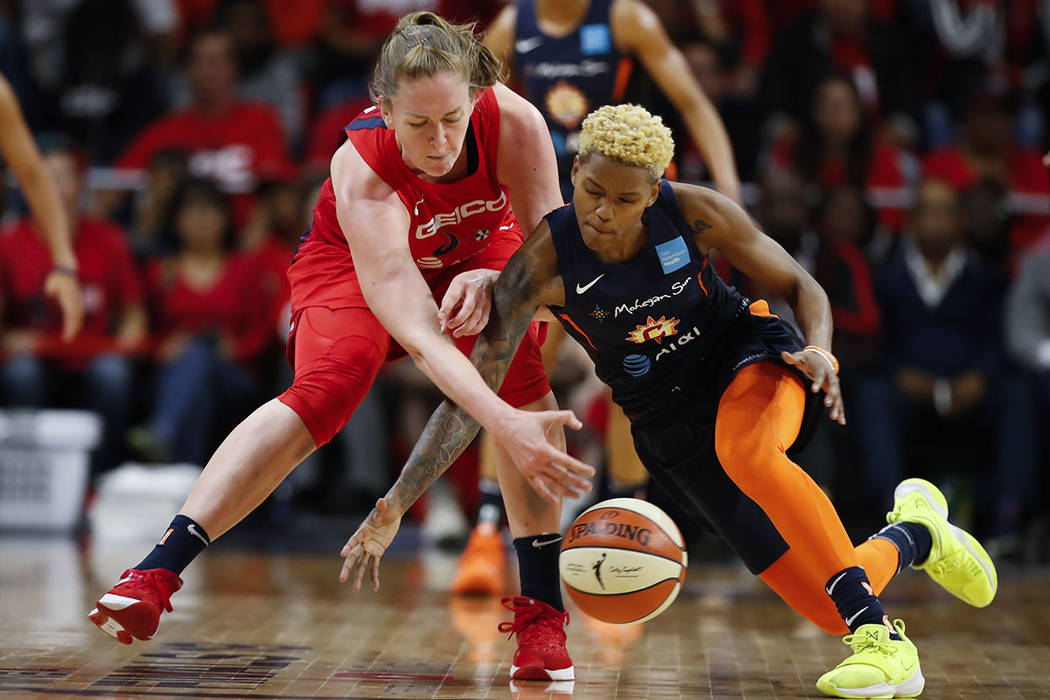 La centro de las Washington Mystics, Emma Meesseman, a la izquierda, y la guardia del Connectic ...