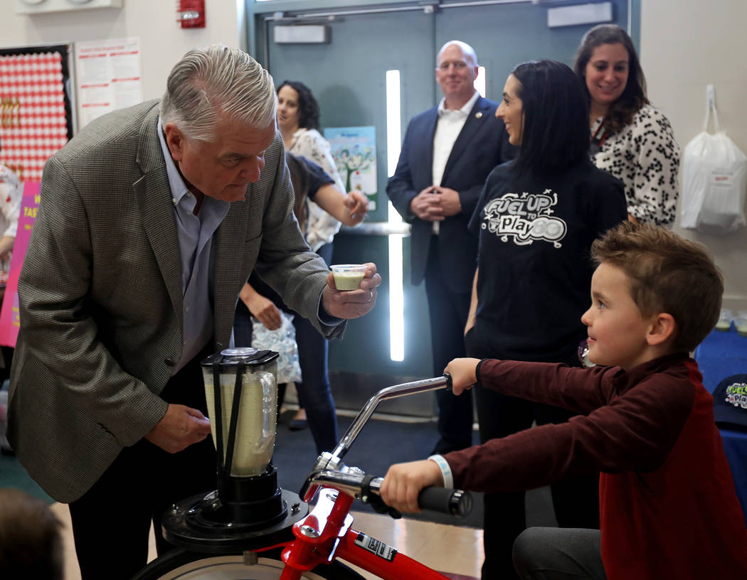 El gobernador Steve Sisolak habla con Blake Tary, de seis años, mientras pedalea una bicicleta ...