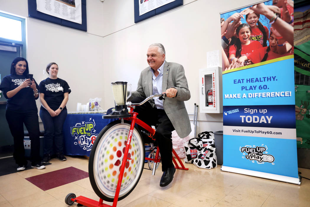 El gobernador Steve Sisolak pedalea una bicicleta que alimenta una licuadora para hacer un bati ...