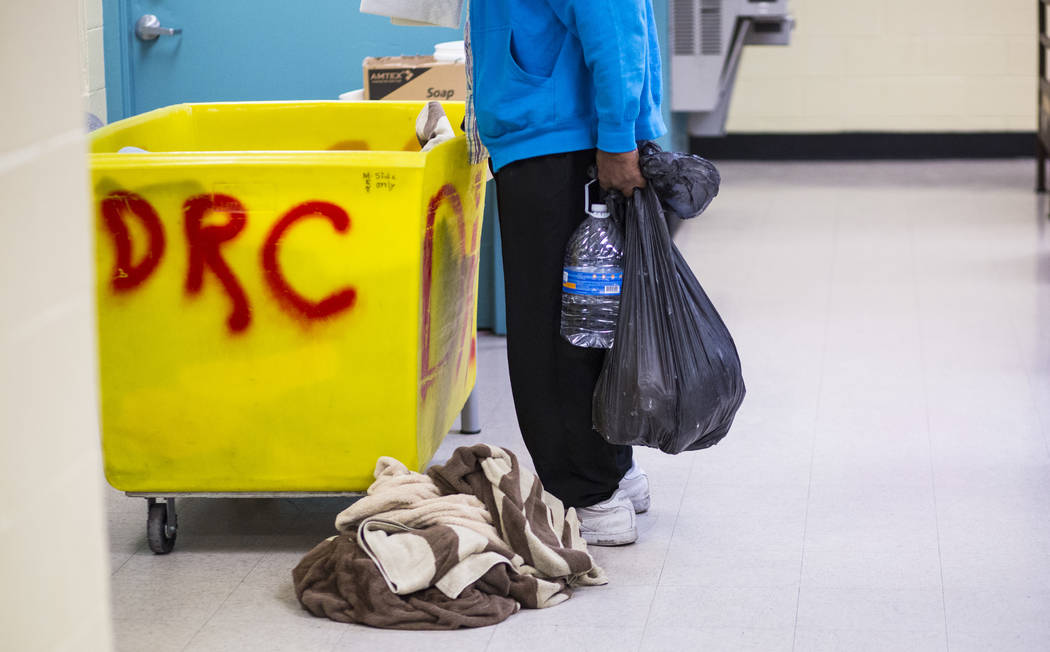 Los patrocinados del refugio para personas sin hogar Salvation Army revisan sus suministros cer ...