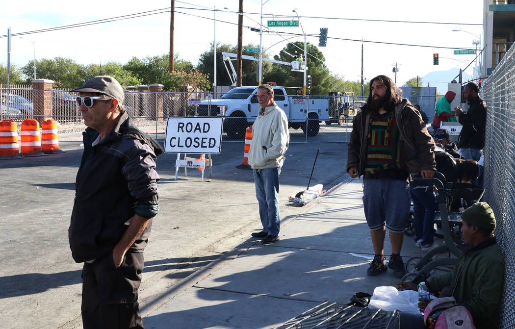 Clientes caminan al lado de un letrero de carretera cerrada afuera del Courtyard Homeless Resou ...