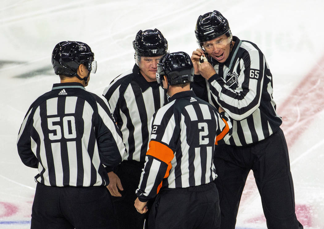 En el hielo, los árbitros se unen para dar indicaciones a los Vegas Golden Knights contra una ...