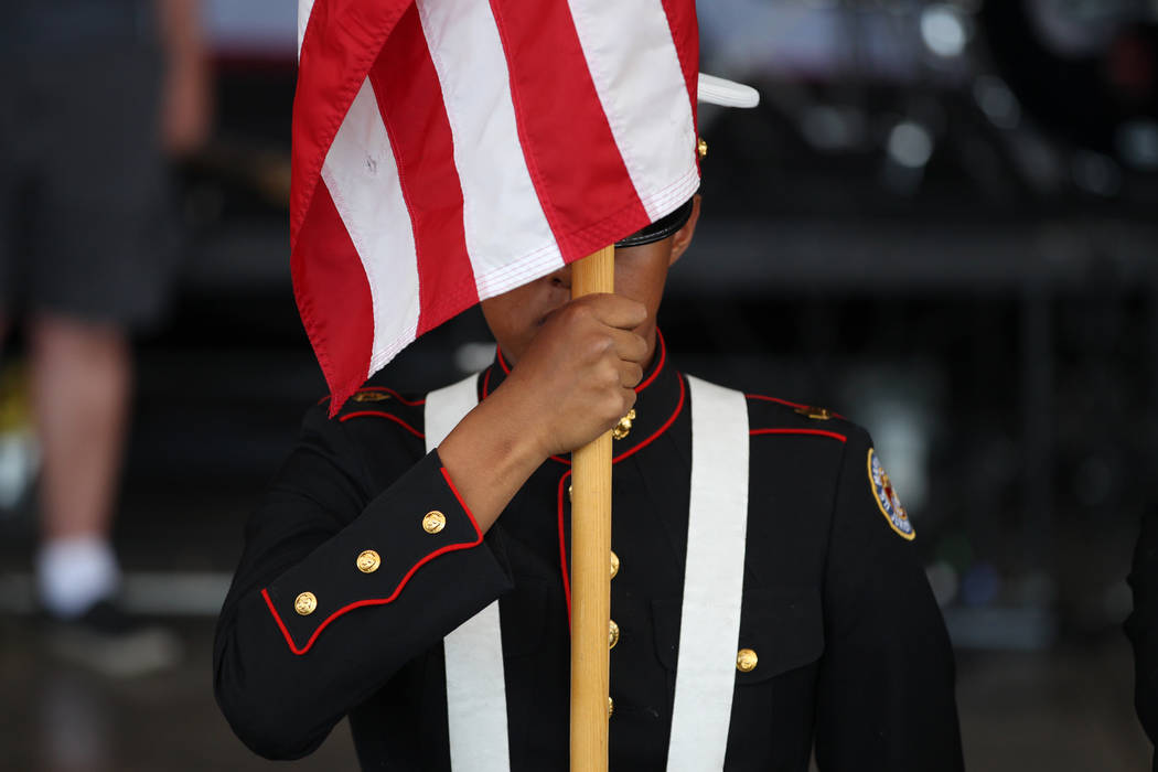Un miembro de la guardia de color JROTC de la preparatoria básica presenta la bandera durante ...