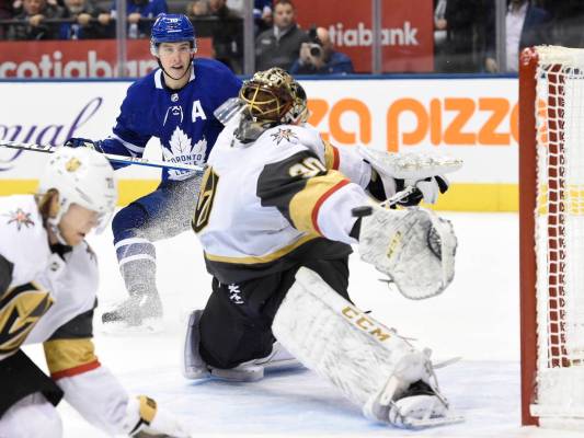 El centro de los Toronto Maple Leafs, Mitchell Marner, atrás, mira cómo un gol del centro Joh ...