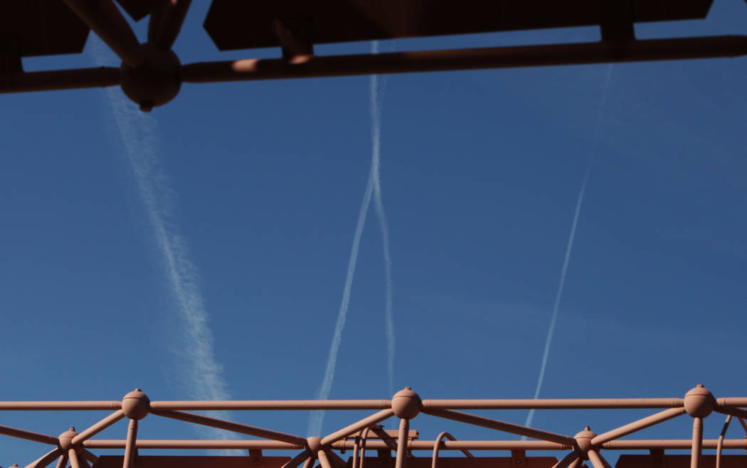 Aviones que vuelan por el cielo azul dejan estelas mientras pasan sobre Las Vegas el miércoles ...