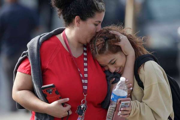 La madre Alicia León, izquierda, besa a su hija, Alejandra Cruz, de décimo grado, mientras se ...