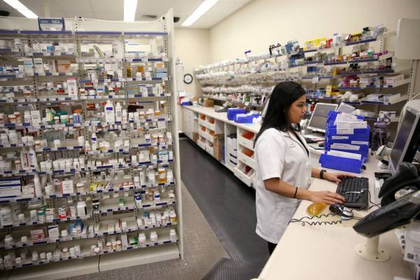 La gerente de farmacia, María Masood, atiende la receta de un cliente en la farmacia Walgreens ...