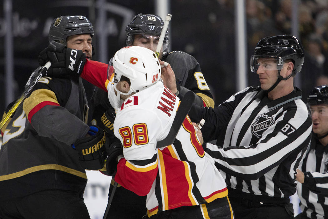 El defensa de los Golden Knights, Deryk Engelland (5), recibe un puñetazo del ala izquierda de ...