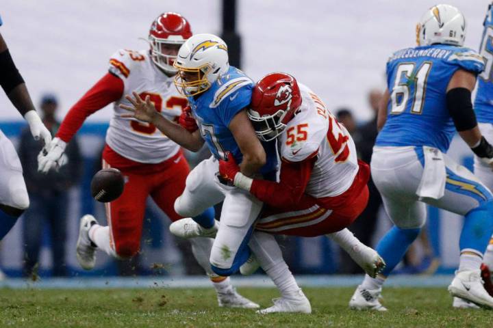 El mariscal de campo de Los Angeles Chargers, Philip Rivers, en el centro, es derribado por el ...