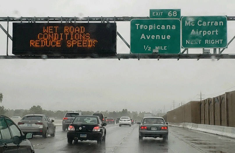 Un letrero advierte a los conductores de las condiciones de la carretera mojada en la US 95 cer ...