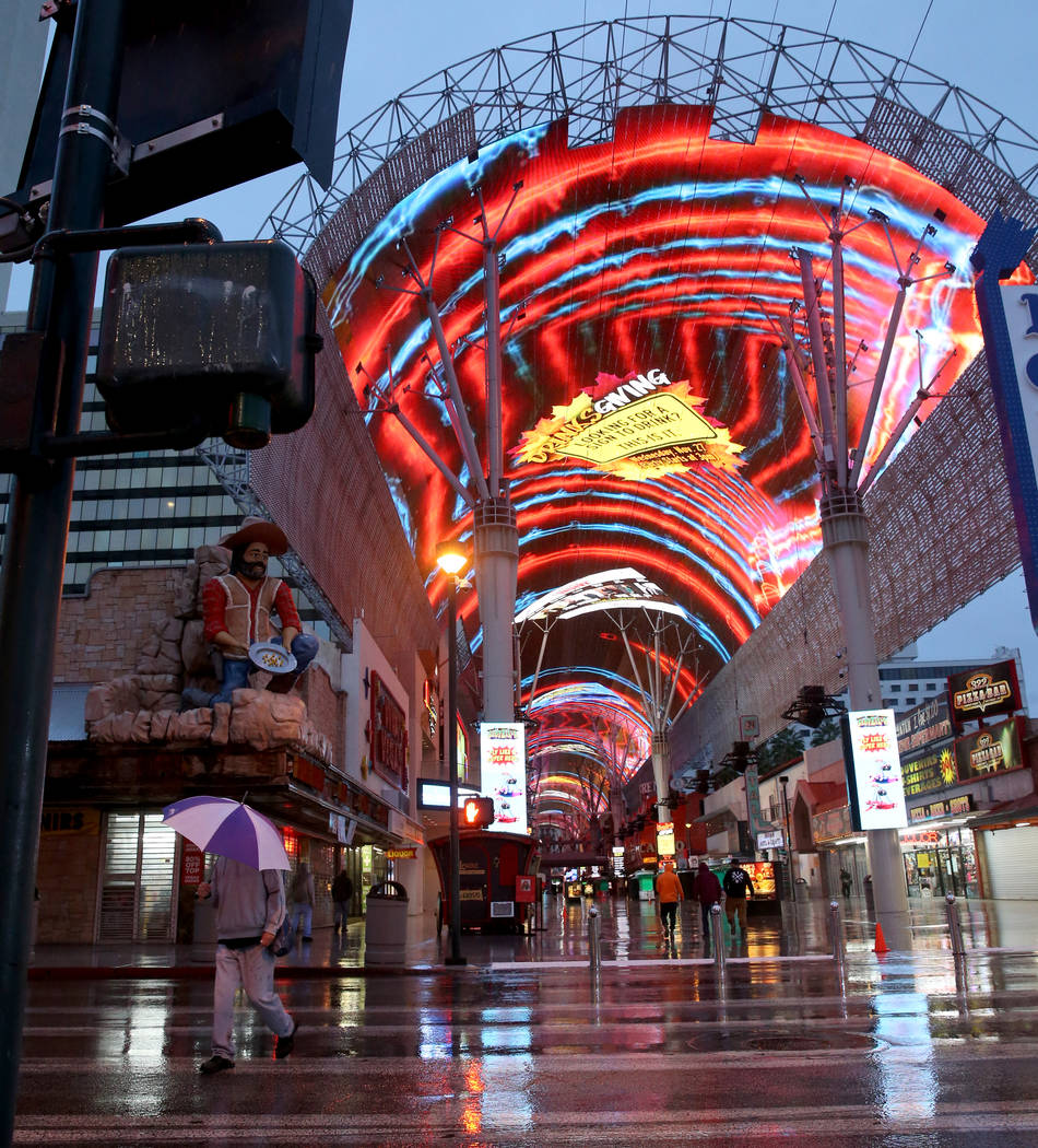 La gente camina a través de Fremont Street Experience en el centro de Las Vegas, el miércoles ...