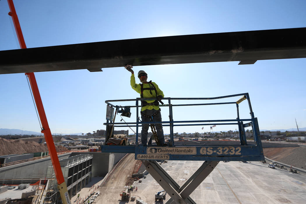 Un trabajador pinta una pieza de la estructura del Estadio Allegiant de Raiders en Las Vegas, e ...