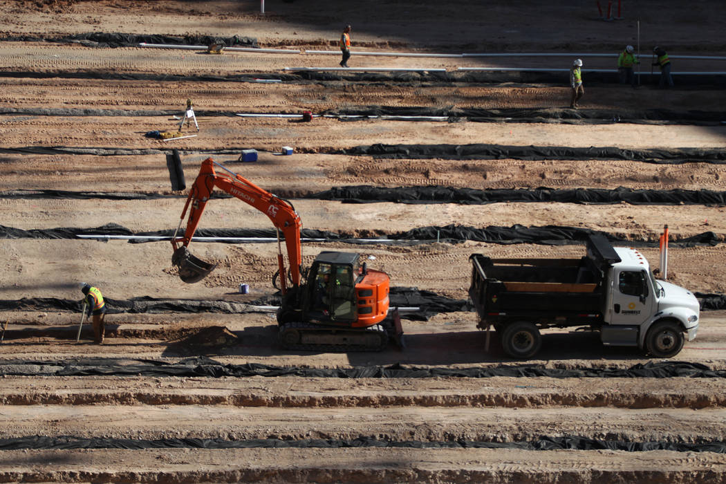Trabajadores en el nivel del campo del sitio de construcción del Raiders Allegiant Stadium en ...