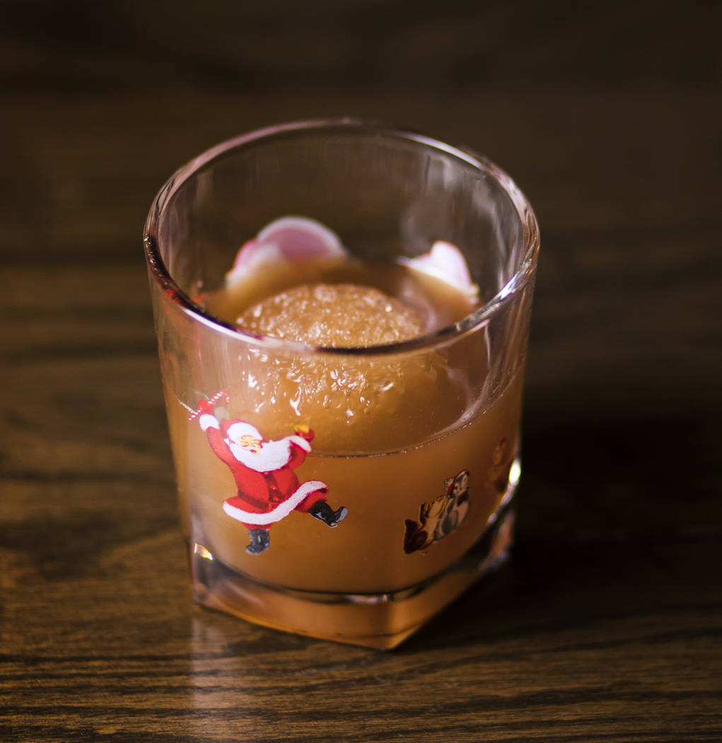 El Snowball Old-Fashioned hecho de bourbon de nuez caramelizado, jarabe de melaza con especias, ...