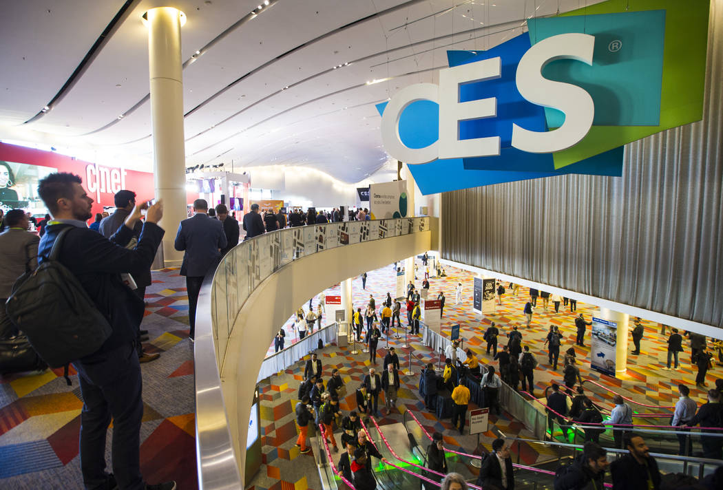 Los asistentes al CES se dirigen a la Sands Expo and Convention Center en Las Vegas el miércol ...