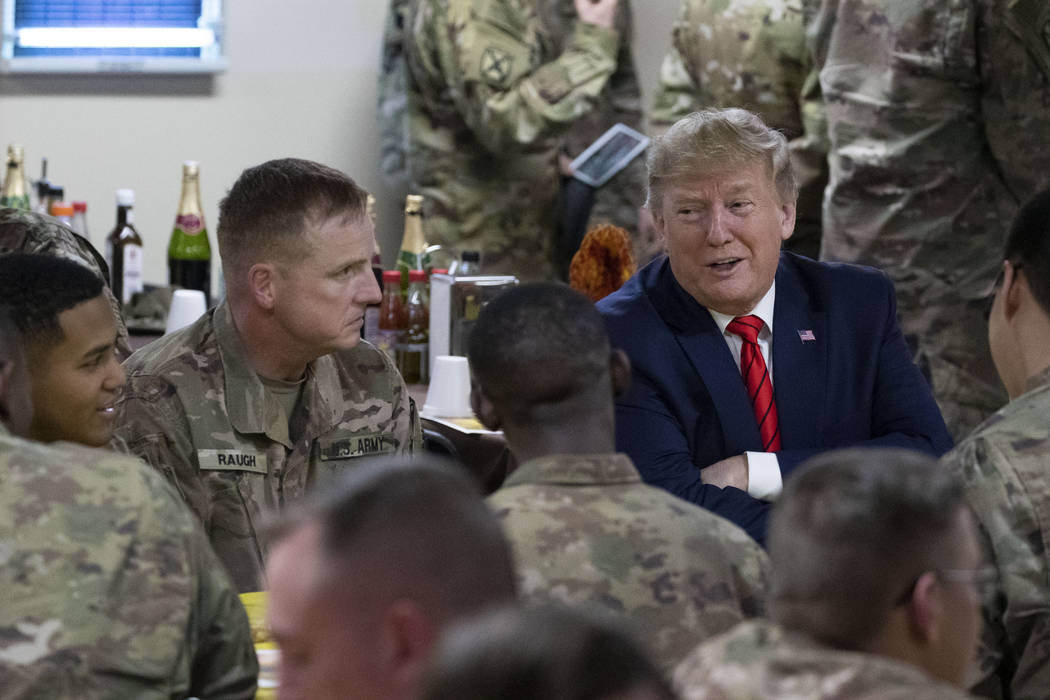 El presidente Donald Trump habla con miembros del Ejército durante una visita sorpresa del Dí ...