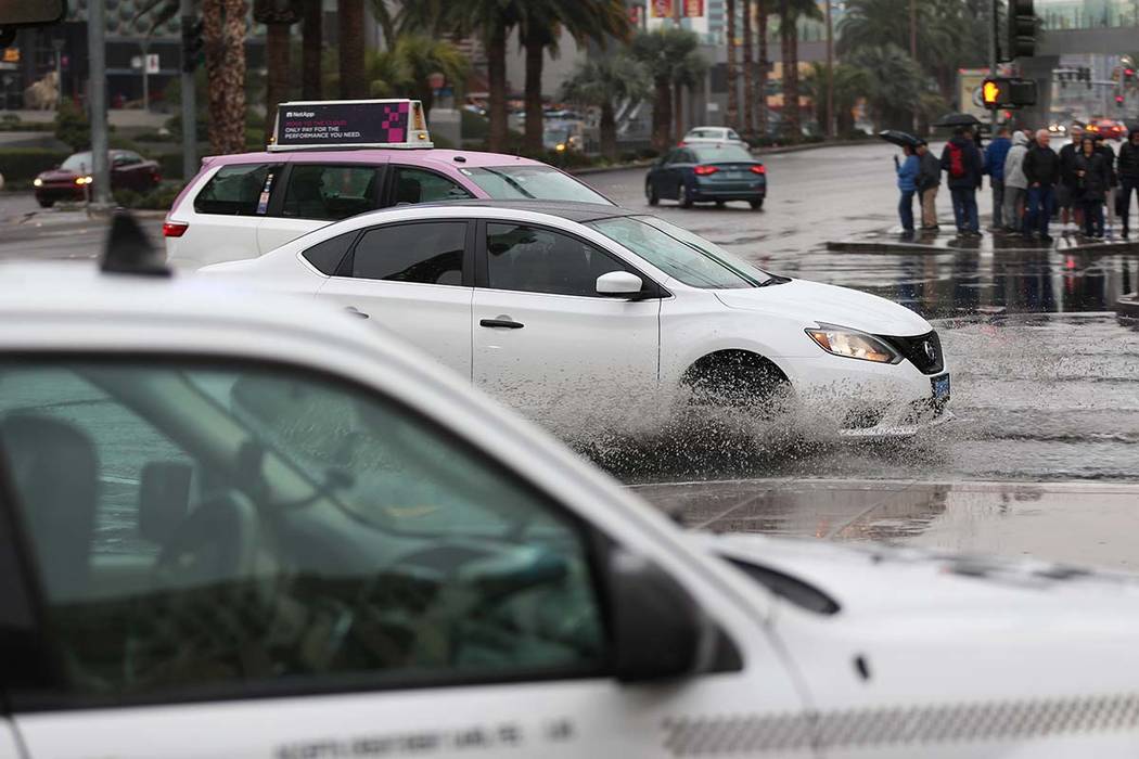 Los conductores se dirigen al casino-hotel Bellagio en Las Vegas en una intersección inundada ...