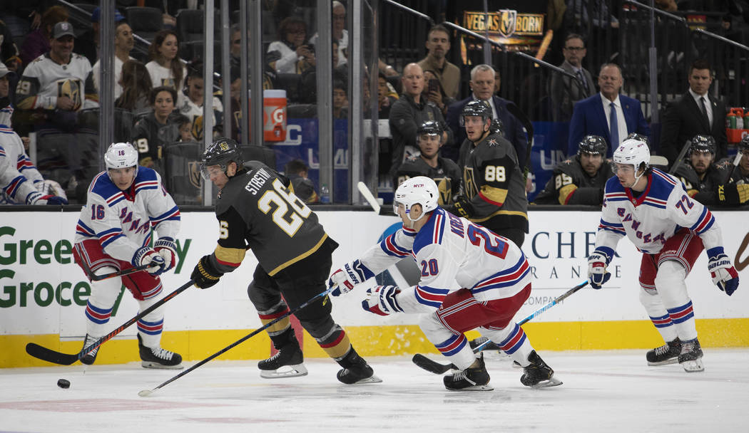 El centro de los Golden Knights, Paul Stastny (26), va por el puck junto al centro de los Range ...