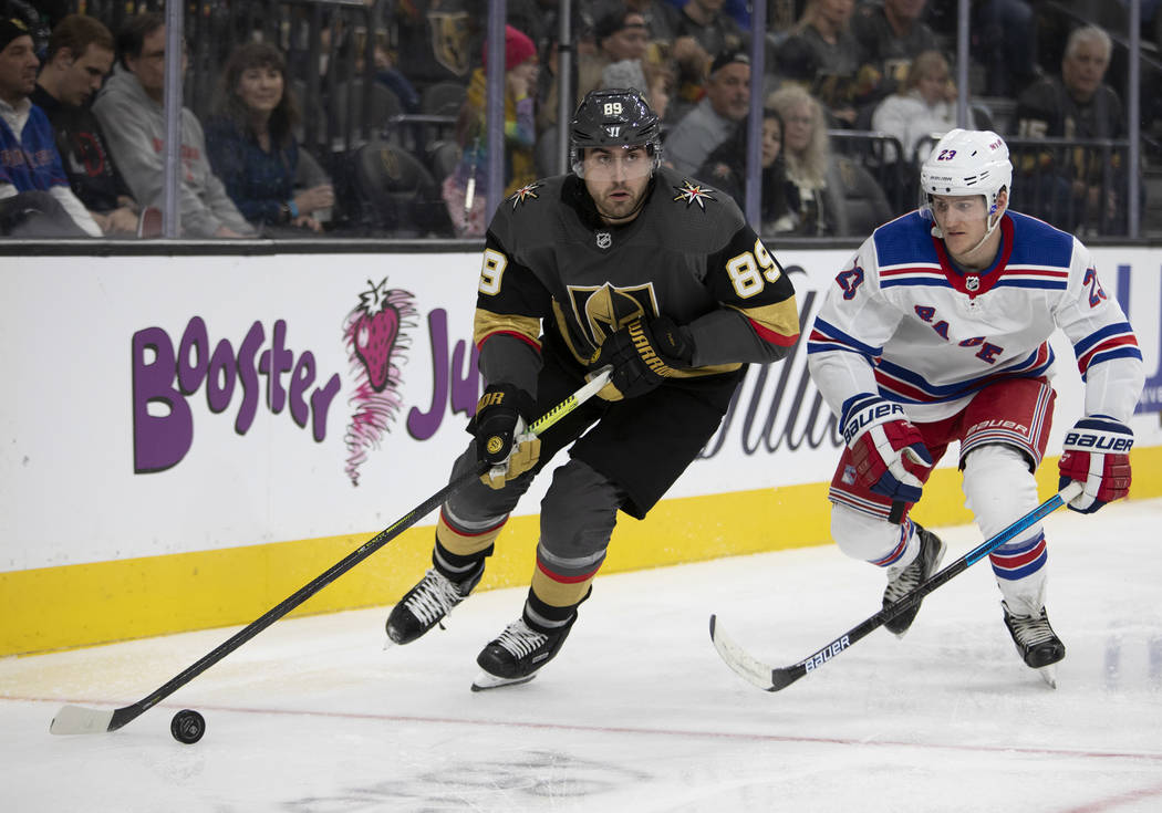 El ala derecha de los Golden Knights, Alex Tuch (89), parece pasar el puck junto al defensa de ...