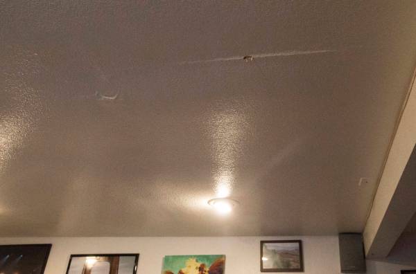 Un agujero y marcas a causa de una fuga en el techo de la sala de estar en la casa de alquiler ...