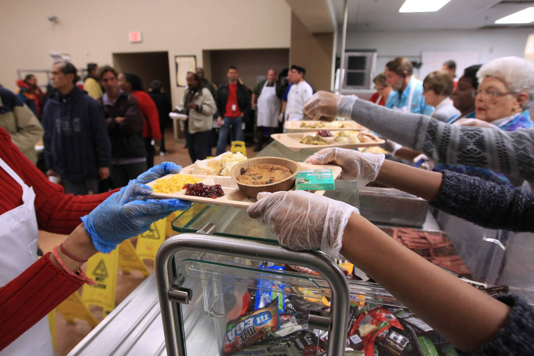 Voluntarios sirven bandejas de pavo durante la comida de Navidad en Las Vegas Rescue Mission el ...