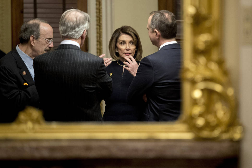 La presidenta de la Cámara de Representantes, Nancy Pelosi, al centro, habla con el presidente ...