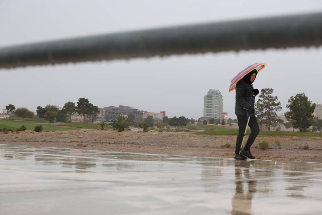 Un individuo hace una caminata matutina mientras la lluvia cae en el valle de Las Vegas el juev ...