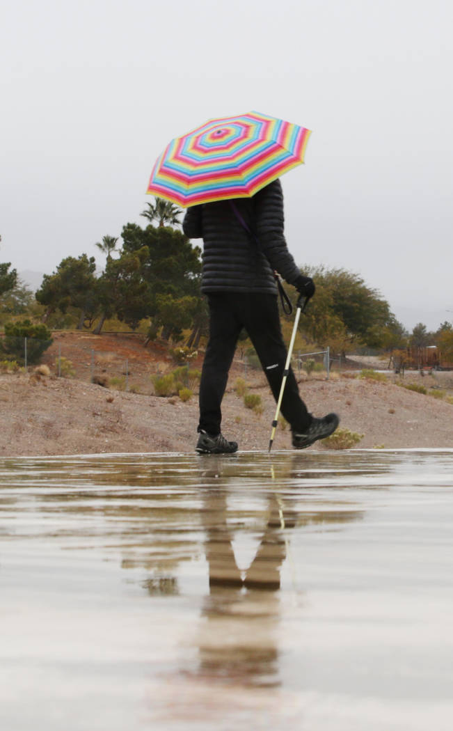 Un individuo hace una caminata matutina mientras la lluvia cae en el valle de Las Vegas el juev ...