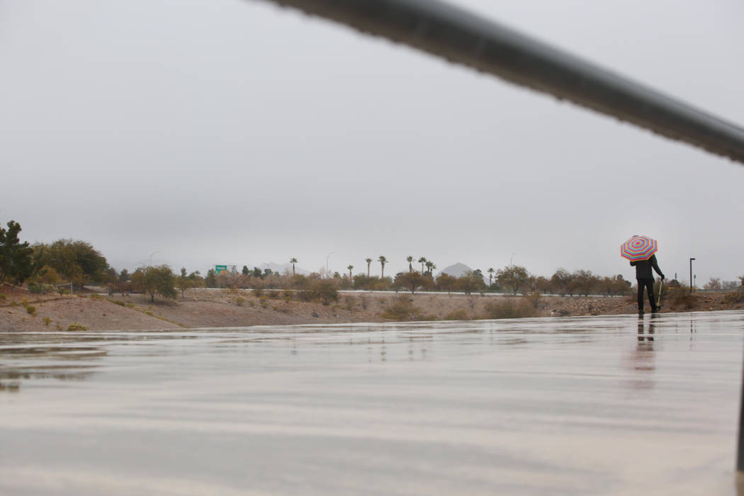 Un individuo hace una caminata matutina mientras la lluvia cae en el valle de Las Vegas el juev ...