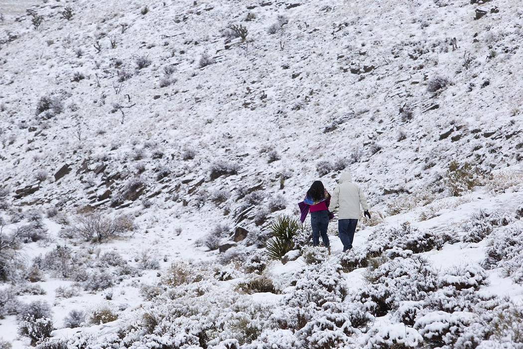 La gente camina por la nieve en el mirador del Cañón Red Rock el jueves, 26 de diciembre de 2 ...