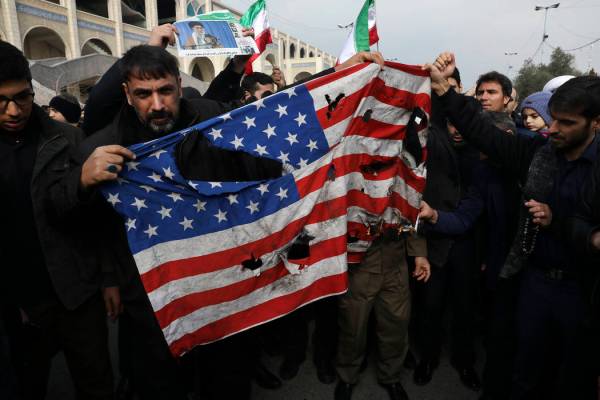 Manifestantes queman una bandera estadounidense durante una manifestación por el ataque aéreo ...