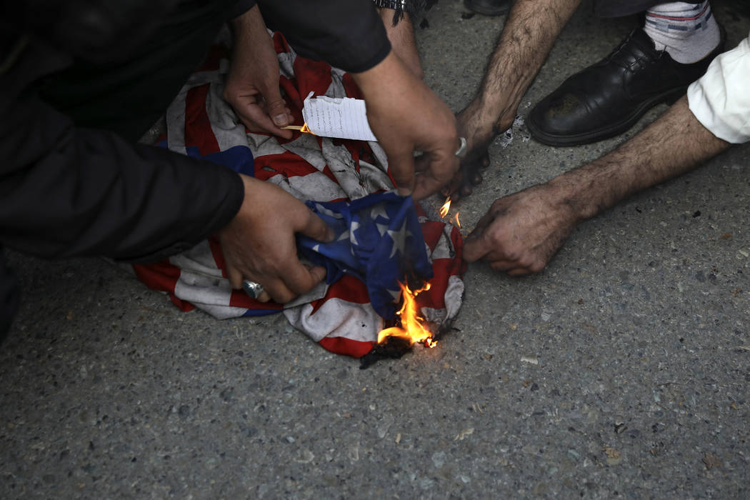 Manifestantes queman una bandera estadounidense durante una manifestación por el ataque aéreo ...