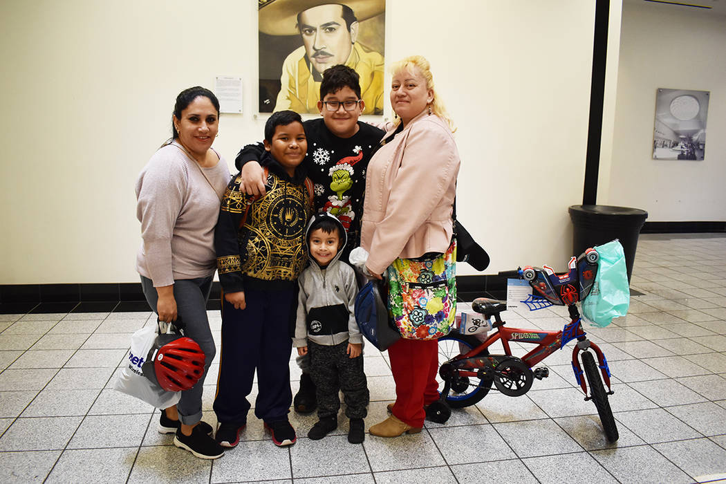 La señora Marisel, derecha, llevó a sus hijos al festival de Reyes Magos, el mayor, Brandon s ...