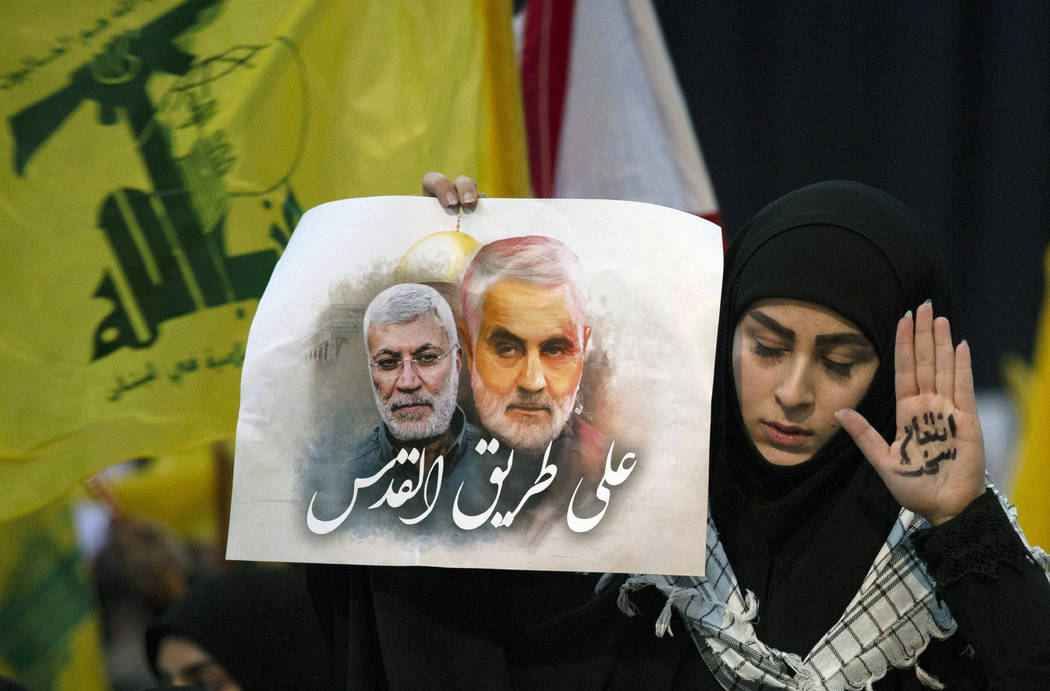 Una partidaria del líder de Hezbolá, Sayyed Hassan Nasrallah, lleva en la mano las palabras " ...