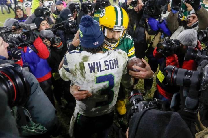 Aaron Rodgers de los Green Bay Packers habla con Russell Wilson de los Seattle Seahawks despué ...