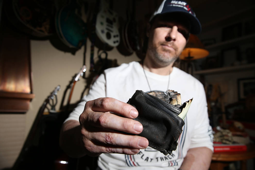 Scott Booth, ex piloto de Papillon Grand Canyon Helicopters, muestra su billetera carbonizada e ...