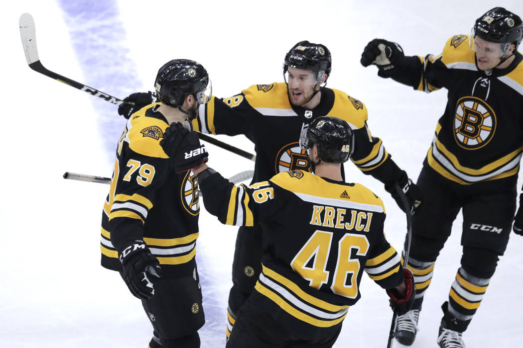 El defensa de los Boston Bruins, Jeremy Lauzon (79), recibe felicitaciones de sus compañeros t ...