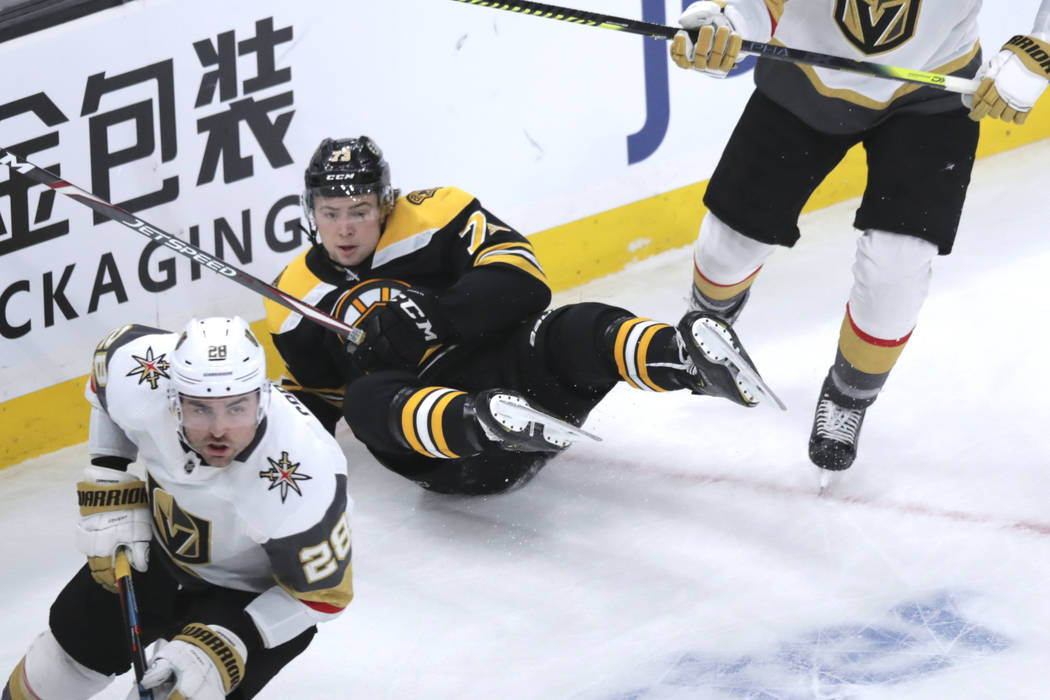 El defensa de los Boston Bruins, Charlie McAvoy (73), cae al hielo durante el primer tiempo de ...