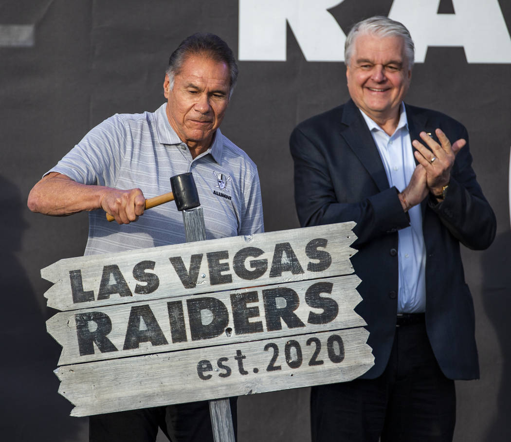 El ex-grande de los Oakland Raiders, Jim Plunkett, izquierda, clava un cartel ceremonial en el ...