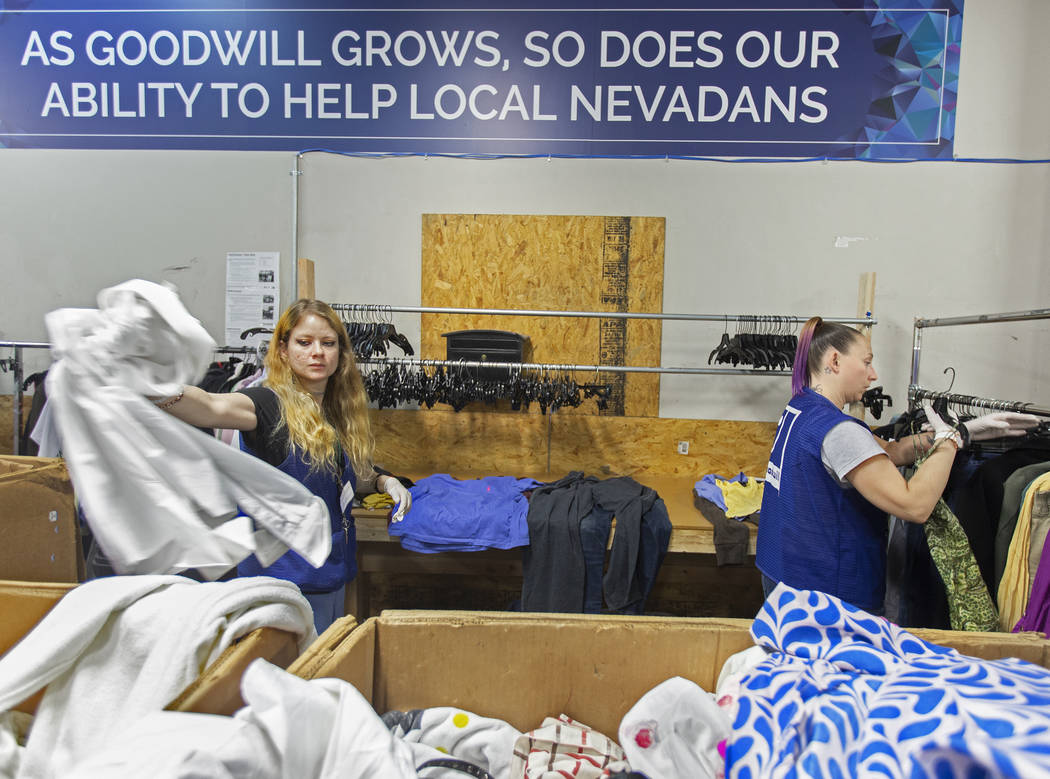 Shawnee Seay, izquierda, y Katie Silber clasifican la ropa donada a Goodwill del Sur de Nevada ...