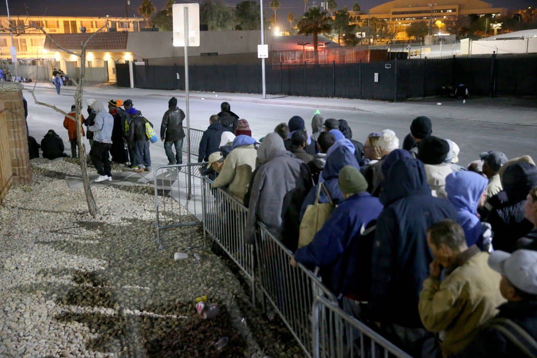 La gente se forma para solicitar las camas del refugio nocturno de Catholic Charities en Las Ve ...