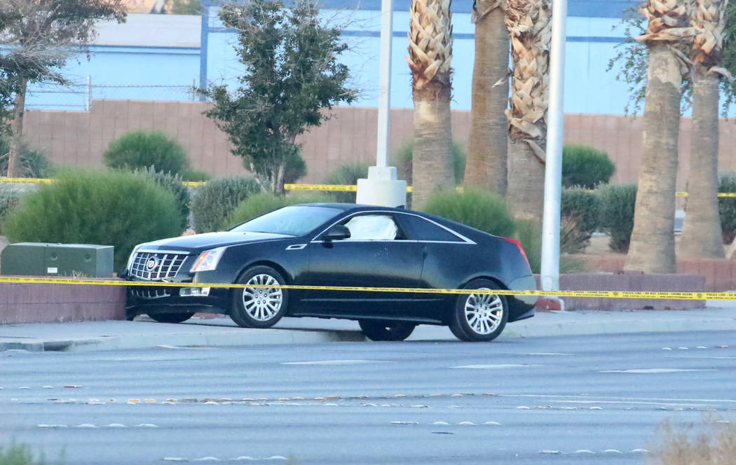 Un Cadillac negro es fotografiado mientras la policía investiga un homicidio y un accidente ve ...